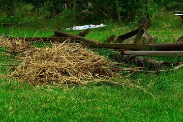 Resztki siana na tle maszyny do orania pola chwile po skończonej pracy na polskiej wsi © Kamil Cukrowski