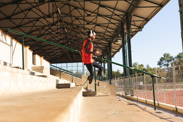 Male Black African American athlete with prosthetic leg running down the stairs
