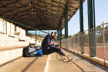 Male Black African American athlete with prosthetic leg sitting on stairs