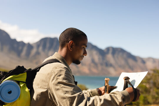 Black African American Man checking map while hiking - Powered by Adobe