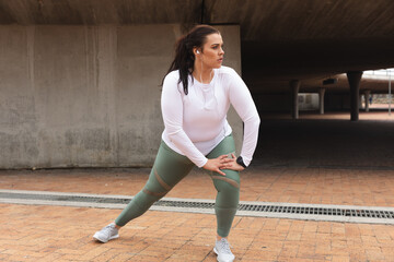 Curvy Caucasian woman exercising in a city