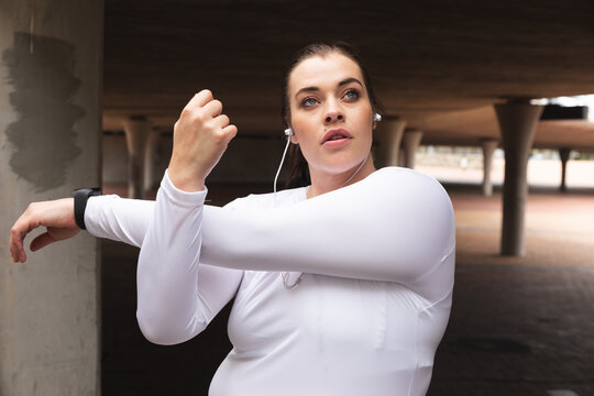 Curvy Caucasian woman exercising in a city