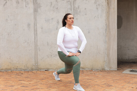 Curvy Caucasian woman exercising in a city