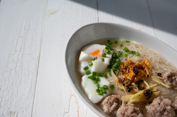 Thai style clear soup rice noodle in traditional bowl. Selective focus