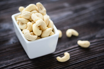 Fototapeta na wymiar Full Raw Cashew Nuts in white ceramic bowl