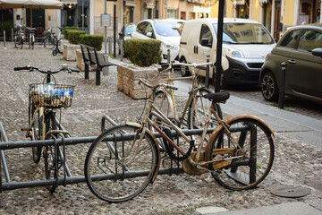 Fototapeta na wymiar Several old bicycles stand on the cobblestone street of the old city