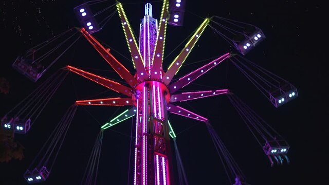 4K Tall bright colourful merry-go-round in amusement park at night. Amusement concept, entertainment concept.