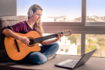 Woman learning online how to play guitar