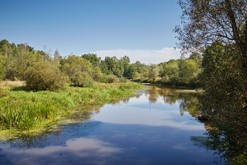 Scenic landscape with calm river and green vegetation.