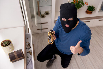 Camera view of male robber stealing things