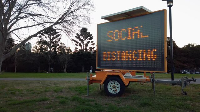 Social Distancing warning sign on trailer mount outdoor in park of Sydney, slow