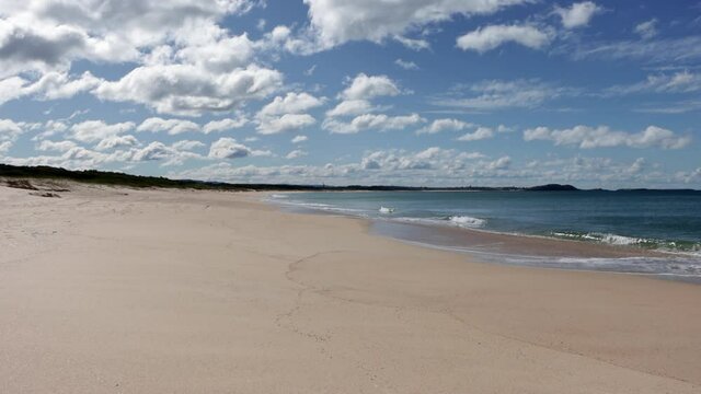 Huskisson Beach at Jervis Bay in Australia with calm waves and clouds rolling, Locked shot