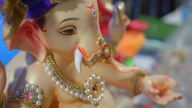 Man hands makes and decorates Ganesha Ganapati Idol during Ganesh festival in Mumbai India during covid pandemic.