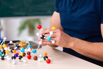 Young male scientist sitting in the classroom