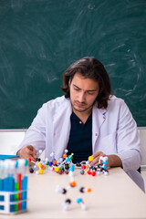 Young male scientist sitting in the classroom