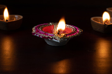 Decorative colourful diya lamps lit during diwali festival. 