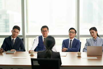 female asian candidate being interviewed by a group of business people