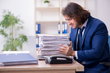 Young male employee unhappy with excessive work