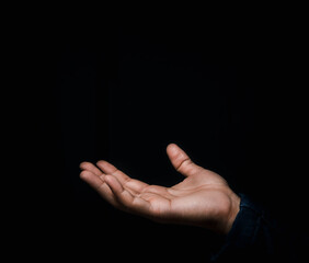 Place your hands face up separately on a black background. The concept is reaching and space available for use, such as yes, text and various effects.