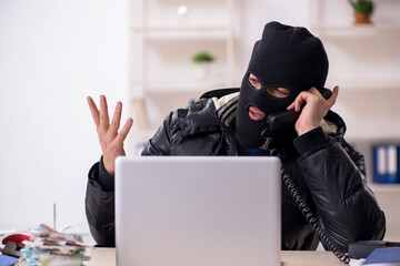 Young male burglar in the office