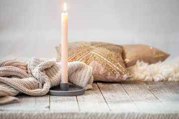 Background with a cozy knitted sweater and a candle.