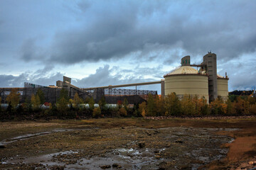 Fototapeta na wymiar Lumber Mill near the sea with storm clouds