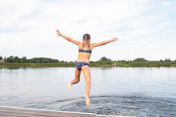 Fototapeta na wymiar Diving. Teenage girl is having fun and splashing in the water. Summer vacation concept
