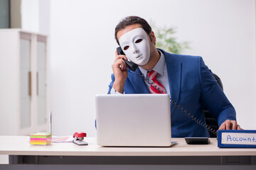 Male employee with mask in hipocrisy concept