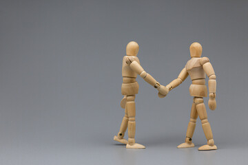 Wooden figure businessman shaking hand for congratulate with team