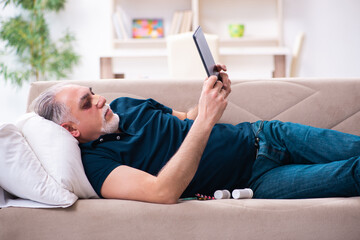 Old man with injured eyes resting at home