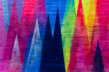 Backsteinmauer in leuchtenden Farben mit geometrischen Figuren bemalt © IzzetNoyan