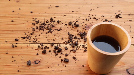 coffee beans and cup on the wooden background.