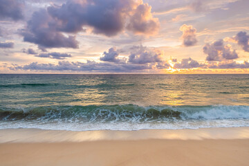 Landscape green color sea with waves blowing against beach and cloudsy in blue sky within evening orange light of sunset look so beautiful background.