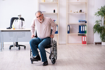 Fototapeta na wymiar Old man in wheel-chair visiting dead doctor