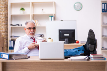 Old male employee enjoying coffee during coffee break