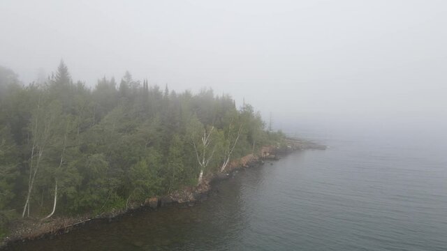 Foggy  day at Lake Superior North Shore Minnesota, shore line with pines and threes