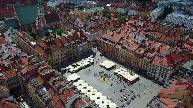 A drone flight over the historic Market Square, with beautiful radiant colors in the buildings, Warsaw, Poland