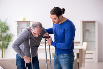 Young man looking after his leg injured father