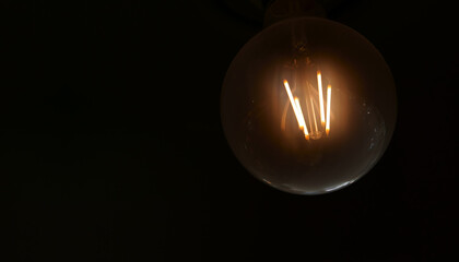 Light in darkness or old incandescent lamp with warm white for business idea and vision solution or...