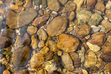 Fototapeta na wymiar pebble or gravel and round stone beach in stream or river and pond with sea to clear transparent by clean water on top view or foot spa and nature massage and for texture background