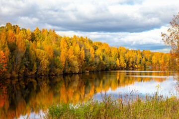 autumn landscape, golden trees are reflecting in blue water, travel through the national park, forest lake