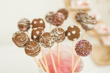 Close up of small delicious cakepoops in pink and white sweet topping stand with charming decor
