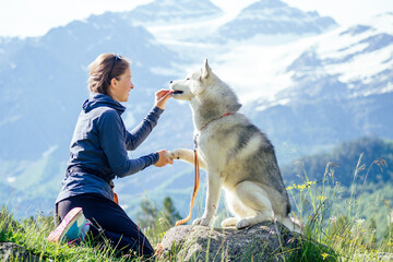 Dog with a woman walking mountains outdoors