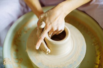 Potter hands sculpts a vase from clay on a Potter close up