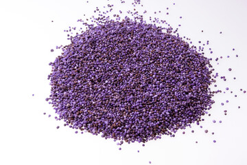 Heap of purple mineral fertilizer isolated on white