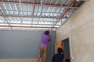 Construction workers install the ceiling