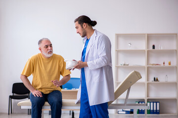 Fototapeta premium Old neck injured man visiting young male doctor