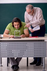 Old professor physicist and young student in the classroom