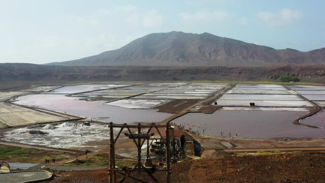 Aerial shot of the Pedra de Lume salt evaporation ponds, inside the crater of an extinct volcano. Camera rises up then tilts down to focus on the majestic salt ponds. Island of Sal, Cabo Verde.