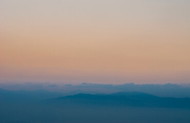Fototapeta na wymiar View of the mist-covered mountains.
